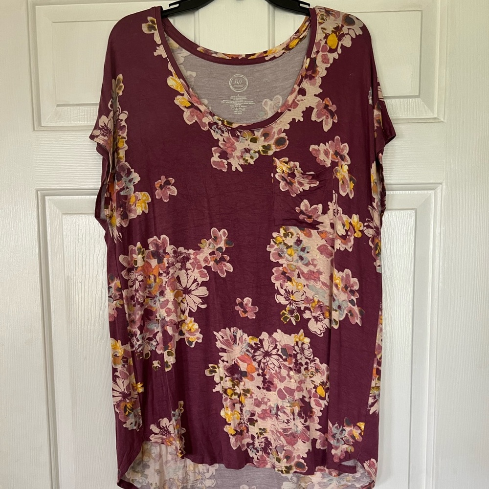 Purple top with pink floral print and front pocket.